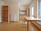 Foto eines Apartments im Wohnheim Bingen des Studierendenwerk Mainz, Tisch, Stuhl, Pentryküche, Kühlschrank, Regal