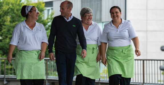 Image shows some persons of the team of Studierendenwerk Mainz walking togehter, laughing