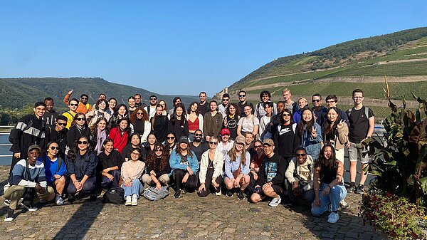 Gruppe von Studis posieren vor dem Rhein in einem Gruppenfoto