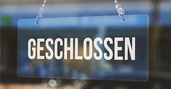 geschlossen auf einem Foto an der Tür hängt ein Schild mit "Geschlossen